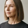 Woman with fine straight hair in a blunt collarbone-length lob showing clean perimeter under side lighting