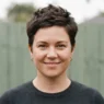 Woman with rounder face wearing textured pixie with volume at crown, photographed outdoors in soft overcast light