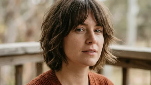 Woman with short textured shag and curtain fringe turning on shaded porch