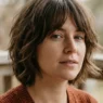 Woman with short textured shag and curtain fringe turning on shaded porch
